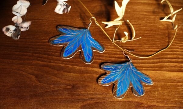 Pendientes elaborados de manera artesanal pintados a mano de hojas con tonos azules inspirados en un Bosque encantado de la flora Colombiana material cobre