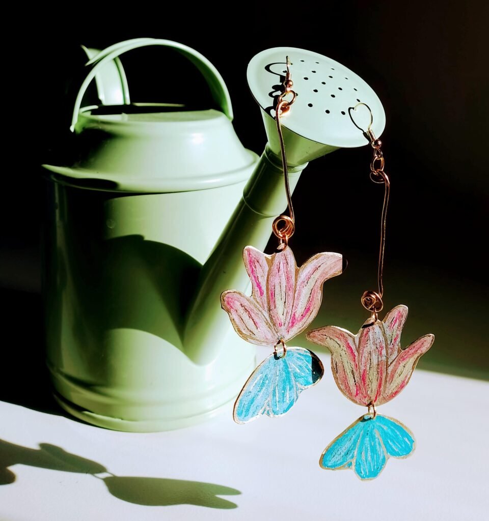 Pendientes de flores artesanales pintados a mano, inspirados en la flora de Pasto, Colombia.