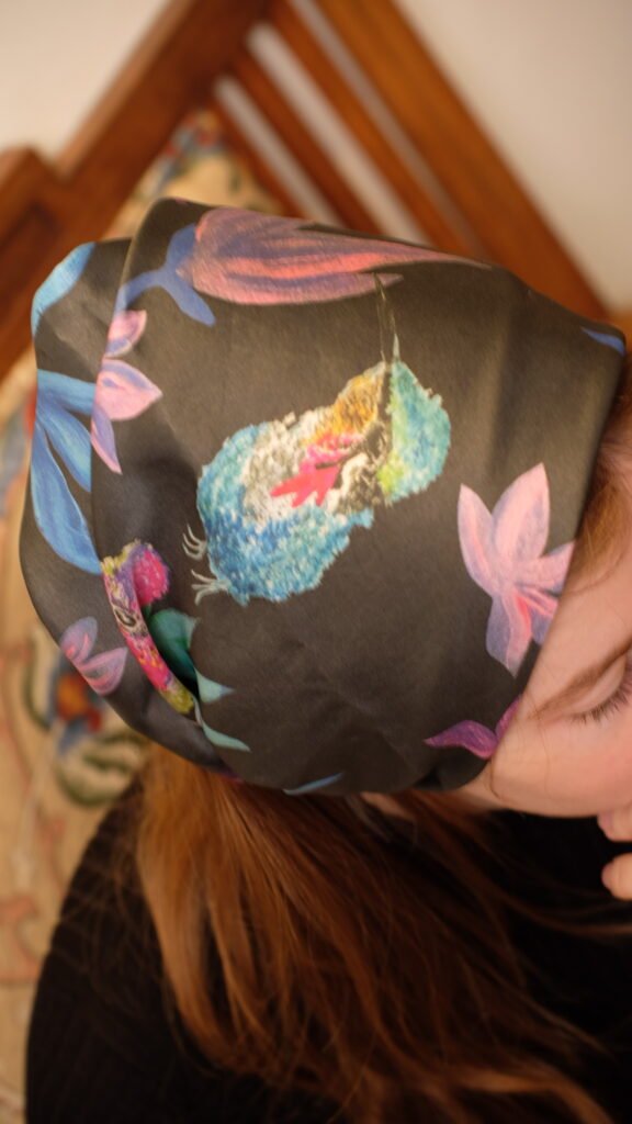 Modelo usando pañoleta con flores y colibríes de colores, mezcla de arte y frescura natural.