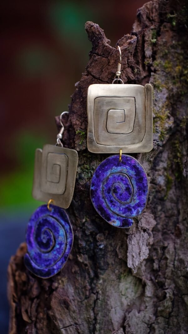 Pendientes Portal de Sol Violeta con figuras en espiral inspirados en la cultura Wayuu colombiana.