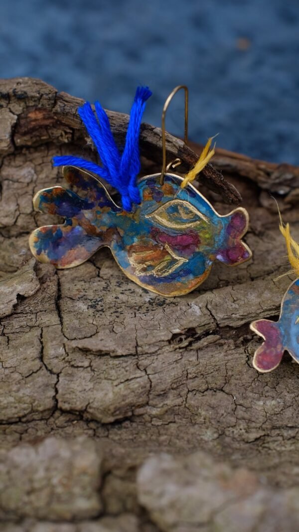 Pendientes en forma de pez elaborados a mano en tono azul y pequenos toques de violeta y naranja