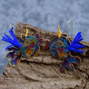 Pendientes en forma de pez elaborados a mano en tono azul y pequenos toques de violeta y naranja.