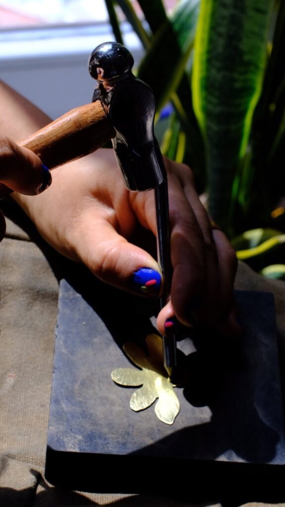 Alta joyería Manos tallando una flor en metal
