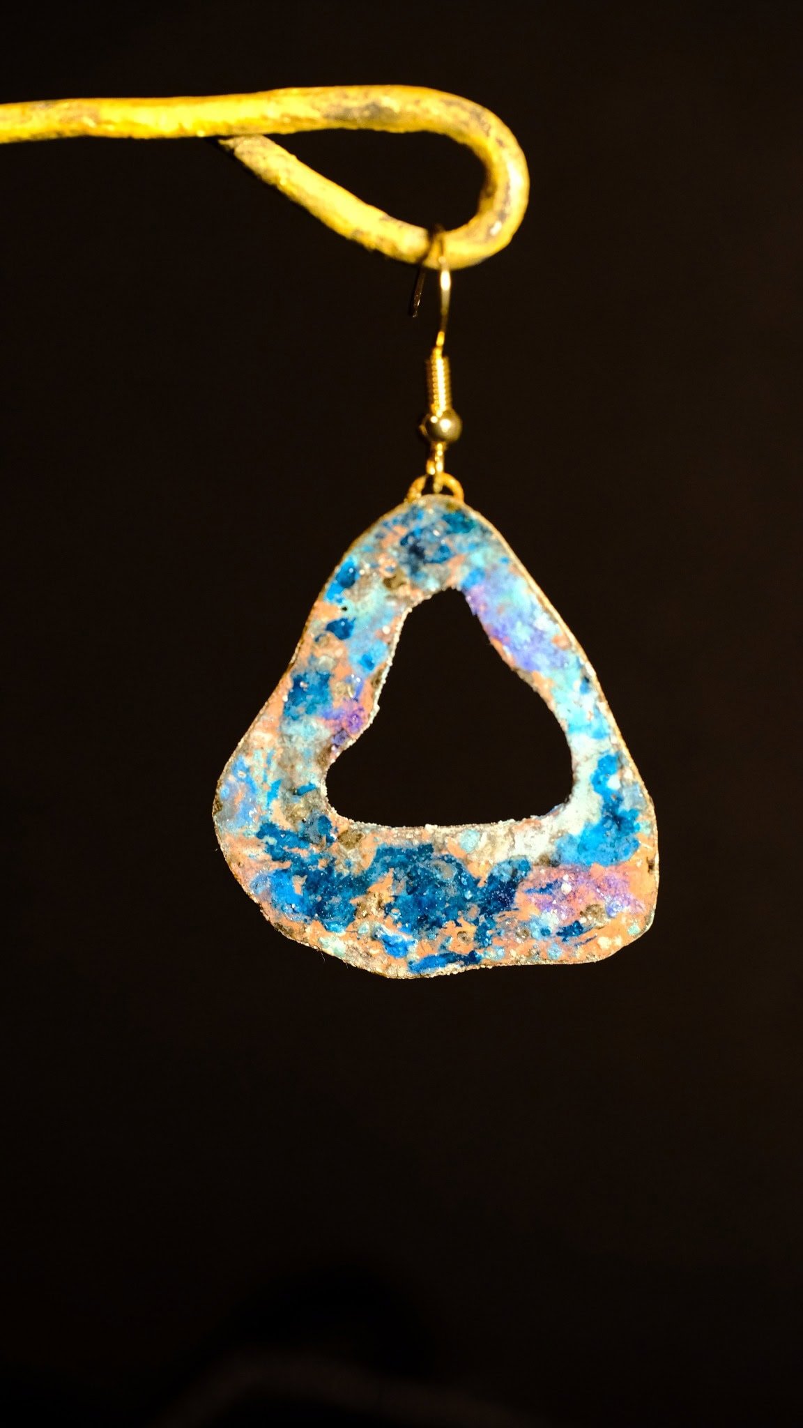 Pendientes artesanales elaborados a mano con formas de triángulos desiguales