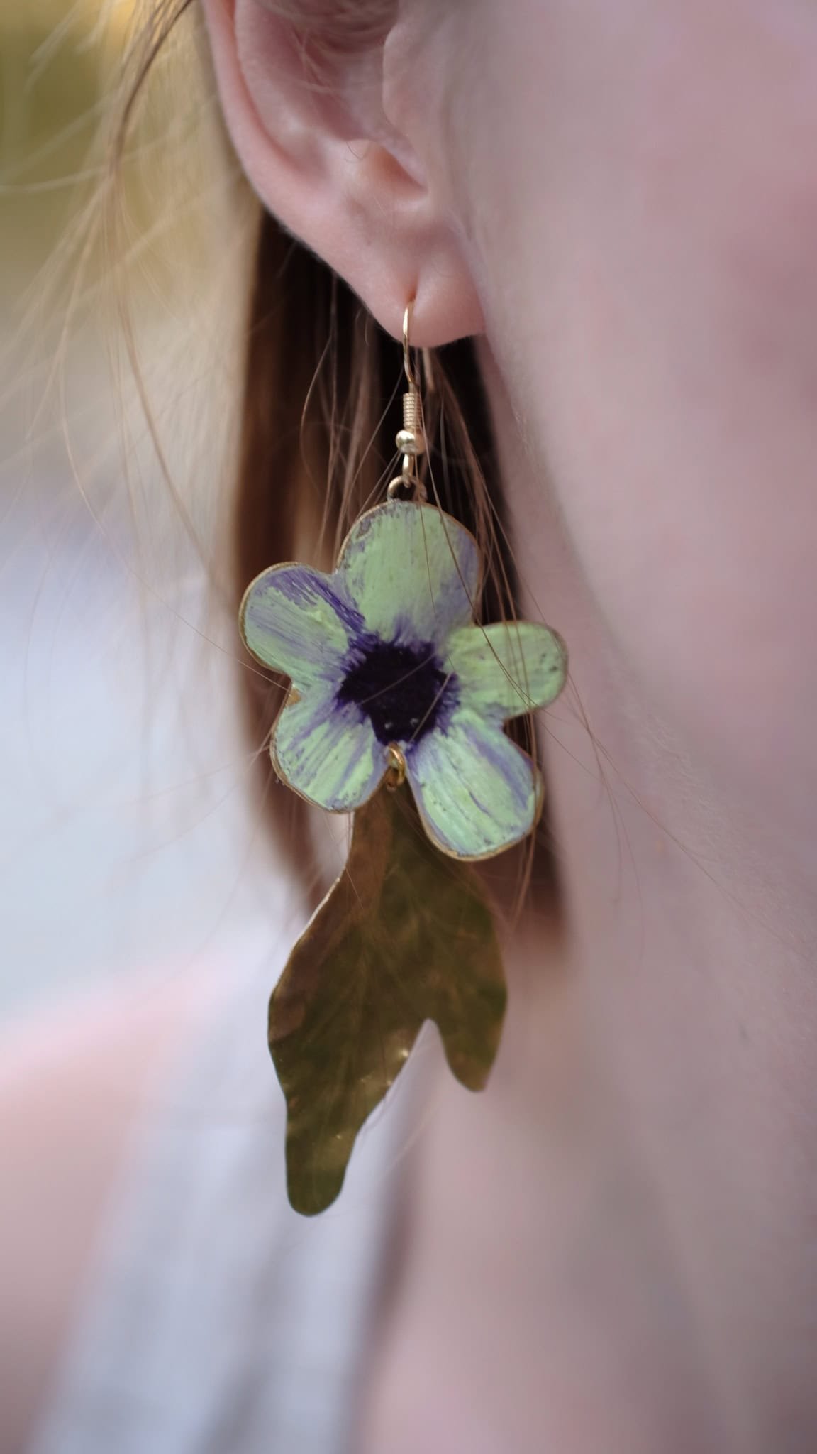Pendientes de flores de manzana verde hechos a mano y pintados con pigmentos artísticos, con tallos bañados en oro de la colección Noa de Andina by Angélica.