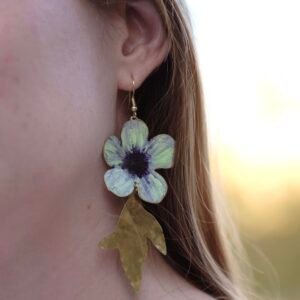 Pendientes de flores de manzana verde hechos a mano y pintados con pigmentos artísticos, con tallos bañados en oro de la colección Noa de Andina by Angélica.