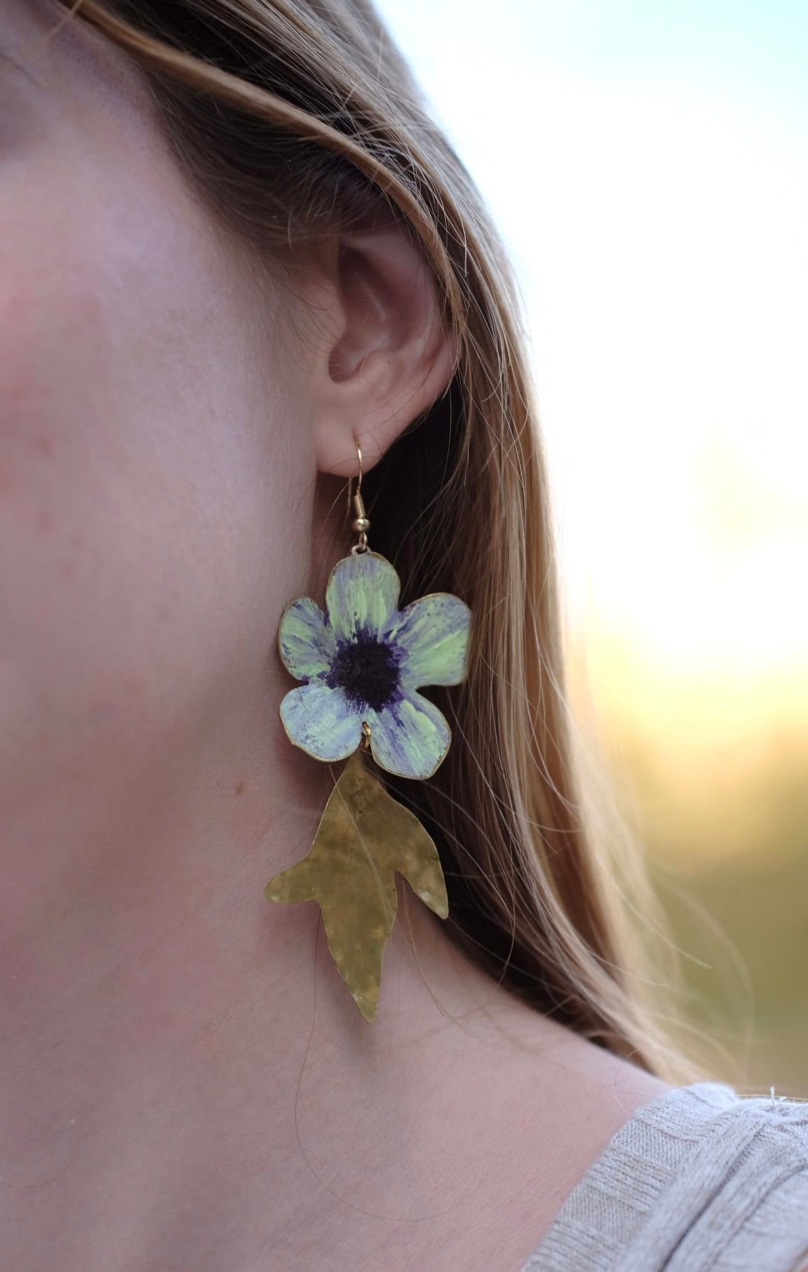 Pendientes de flores de manzana verde hechos a mano y pintados con pigmentos artísticos, con tallos bañados en oro de la colección Noa de Andina by Angélica.