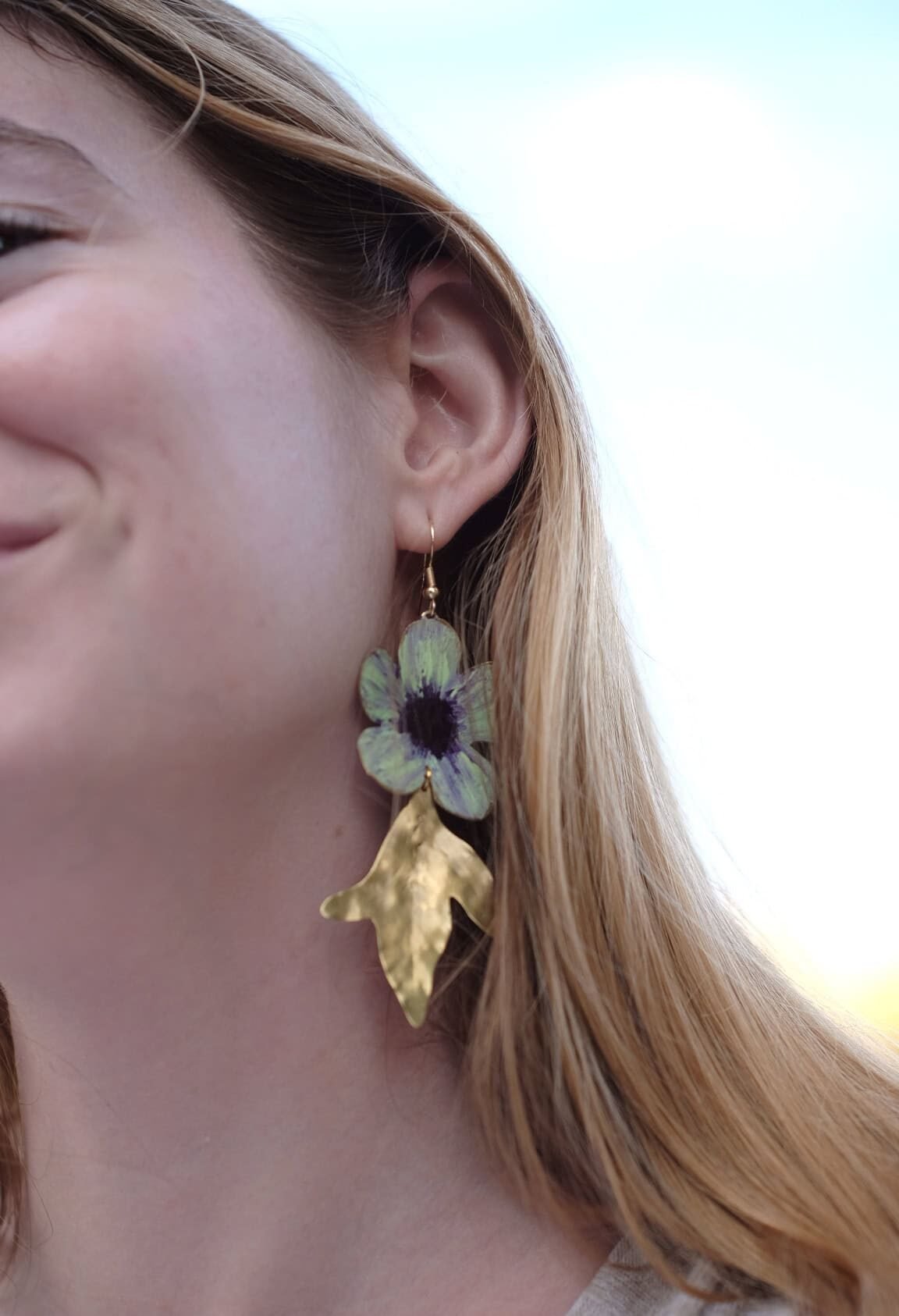 Pendientes de flores de manzana verde hechos a mano y pintados con pigmentos artísticos, con tallos bañados en oro de la colección Noa de Andina by Angélica.