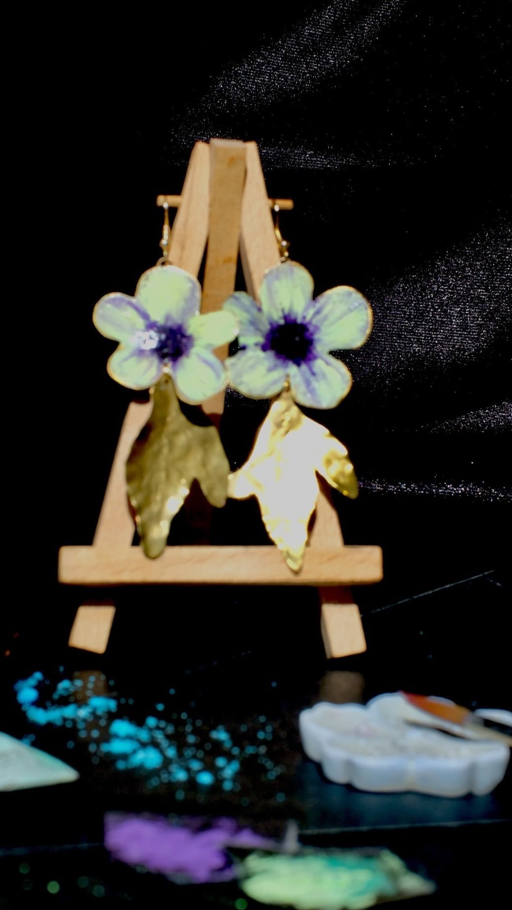 Pendientes de flores de manzana verde hechos a mano y pintados con pigmentos artísticos, con tallos bañados en oro de la colección Noa de Andina by Angélica.