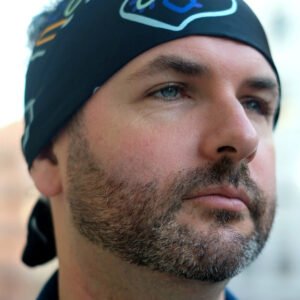 Man wearing hand‑painted digitally printed artisan scarf – sustainable men’s fashion accessory.