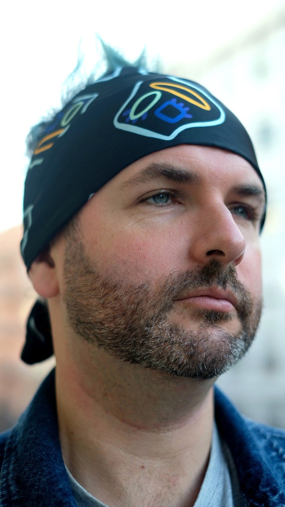 Man wearing hand‑painted digitally printed artisan scarf – sustainable men’s fashion accessory.
